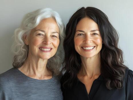 Smiling portrait of two women from different generations, standing next to each other, their facial expressions showing warmth and connection photo