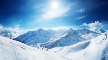 A panoramic view of a snowy mountain range under a bright, crisp blue sky, with peaks glistening in the sunlight photo