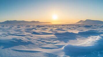 A vast, open tundra under a pale winter sun, with snowdrifts and distant mountain ranges in the background photo