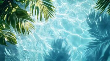 A tropical setting with aqua waves and lush leaf shadows softly playing on a bright blue pool texture photo