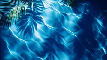 Abstract aqua wave patterns with blurred tropical leaf shadows swaying on a deep blue water texture photo