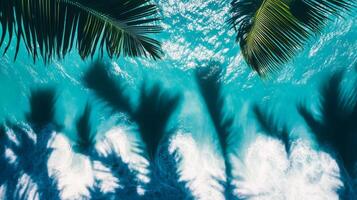 Abstract top view of turquoise waves with sharp tropical leaf shadows dancing on the blue background photo