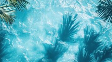Abstract top view of turquoise waves with sharp tropical leaf shadows dancing on the blue background photo