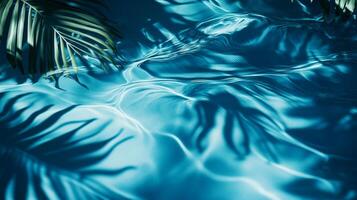 Blue water rippling with the movement of aqua waves, tropical leaves' shadows gracefully falling on the surface photo