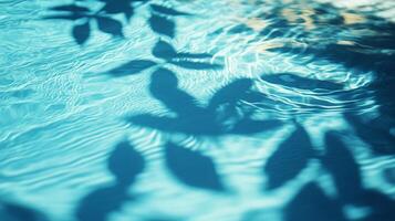 Blue water rippling with the movement of aqua waves, tropical leaves' shadows gracefully falling on the surface photo