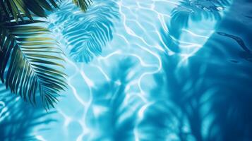 Bright blue pool water with soft ripples, highlighted by tropical leaves' shadows gently swaying on the surface photo