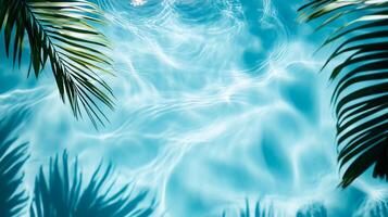 Bright blue pool water with soft ripples, highlighted by tropical leaves' shadows gently swaying on the surface photo