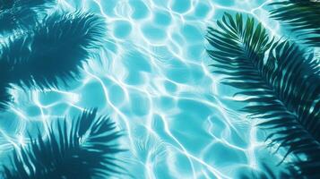 Crystal-clear aqua waves meeting shadows of broad tropical leaves on a sunlit blue pool texture photo