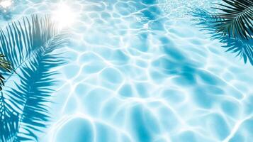 Crystal-clear aqua waves meeting shadows of broad tropical leaves on a sunlit blue pool texture photo