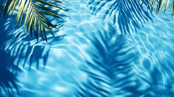 Dynamic water pool texture with soft wave ripples and overlapping tropical leaf shadows against a blue background photo