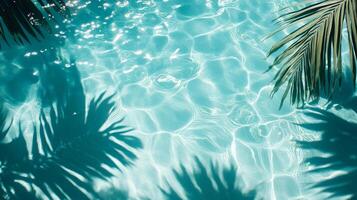 Crystal-clear aqua waves meeting shadows of broad tropical leaves on a sunlit blue pool texture photo