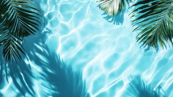 Gentle aqua waves with tropical leaves casting shadows on a bright blue background, rippling water pool texture top view photo