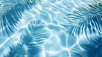 Dynamic water pool texture with soft wave ripples and overlapping tropical leaf shadows against a blue background photo