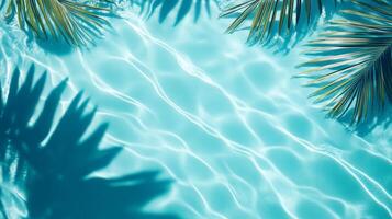 Gentle aqua waves with tropical leaves casting shadows on a bright blue background, rippling water pool texture top view photo