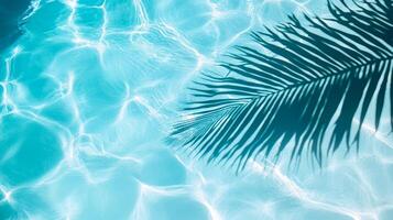 Smooth waves with a palm leaf shadow, creating a tranquil tropical atmosphere on a clear blue pool surface photo