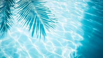 Smooth waves with a palm leaf shadow, creating a tranquil tropical atmosphere on a clear blue pool surface photo