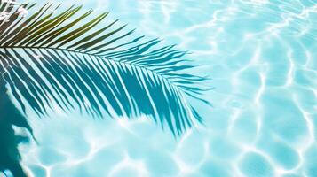 Smooth waves with a palm leaf shadow, creating a tranquil tropical atmosphere on a clear blue pool surface photo