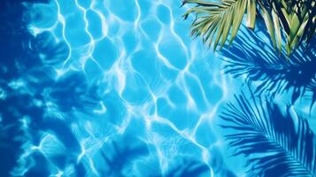 Top view of a crystal blue pool, with layered shadows of tropical foliage on the gentle wave texture photo