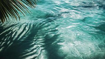 Tropical leaf shadows subtly moving over vibrant aqua waves, the texture of the water highlighted in the sunlight photo