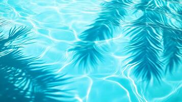 A detailed close-up of aqua waves with palm leaf shadows dancing on the surface of a bright blue pool photo