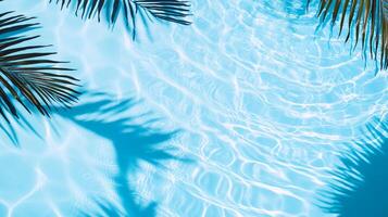 A close-up of water ripples in a pool with palm leaves' shadows creating intricate patterns on the blue surface photo