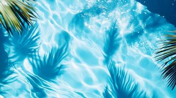 A detailed close-up of aqua waves with palm leaf shadows dancing on the surface of a bright blue pool photo