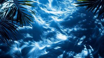A dynamic water texture of blue waves, with sharp tropical leaf shadows enhancing the visual effect photo