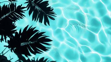 A playful combination of aqua waves and dark tropical leaf shadows contrasting against a light blue pool backdrop photo