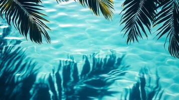 A tranquil water surface with tropical leaves casting dark shadows over bright aqua waves on a blue background photo