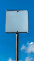 Closeup of a blank rectangular road sign on a tall post, ready for custom text photo