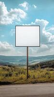 Plain rectangular road sign standing in a rural landscape, blank for custom text photo