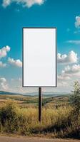 Plain rectangular road sign standing in a rural landscape, blank for custom text photo
