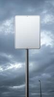 Vertical shot of a blank road sign on a tall post, isolated against a cloudy sky, mockup for text photo