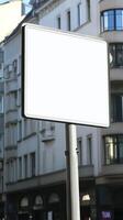 A blank road sign with a white background, mounted on a street post, isolated for mockup photo