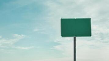 A plain green highway sign on a metal post, positioned against a wide-open sky for custom text photo