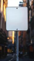 A plain road sign mounted on a pole in the city, against an urban background, with no text photo