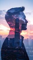 A vertical double exposure of a businessman with his profile blended with a city skyline at sunset photo