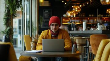 A young entrepreneur working remotely on a laptop in a stylish cafe photo