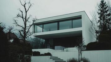 Minimalist white concrete house with large windows and a clean design photo