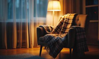 A chair with a blanket draped over it and a lamp in front of it photo