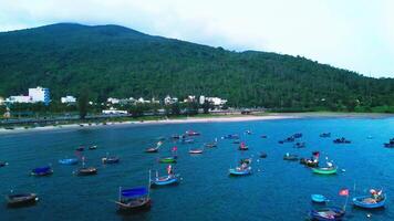 A drone shot of beach water with boats floating near the mountain view video