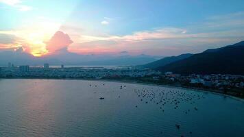 An aerial view a coastal dusk with sunset and mountains video