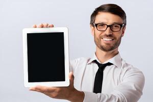 Smiling Business Man Showing Empty Tablet Computer Screen On White Studio Background. Mockup photo