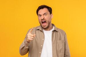A man with angry expression on his face, eyebrows raised and mouth slightly open in shock. His eyes are wide and focus intently on something off-camera, conveying astonishment and disbelief. photo