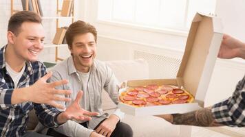Friends taking slices of hot pizza from delivery box, having home party photo