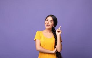 I Have An Idea. Portrait of cheerful young indian woman having great thought, finding inspiration or solution to problem. Positive lady pointing finger up isolated over purple studio wall, copy space photo