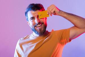 A man is shown holding a bright yellow card up to his face. His facial features are partially obscured by the card as he holds it with both hands. photo