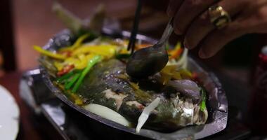 Fried white pomfret is a must-have New Year dish In Vietnam, delicious fish is cooked in a frying pan in a restaurant, immediately cooked in front of customers, boiling and bubbling in water video