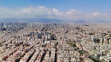 Urban sprawl unfolds under a partly cloudy sky, with distant mountains enhancing the view. A lively cityscape features a blend of residential areas and urban infrastructure video