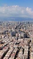 Urban sprawl unfolds under a partly cloudy sky, with distant mountains enhancing the view. A lively cityscape features a blend of residential areas and urban infrastructure video